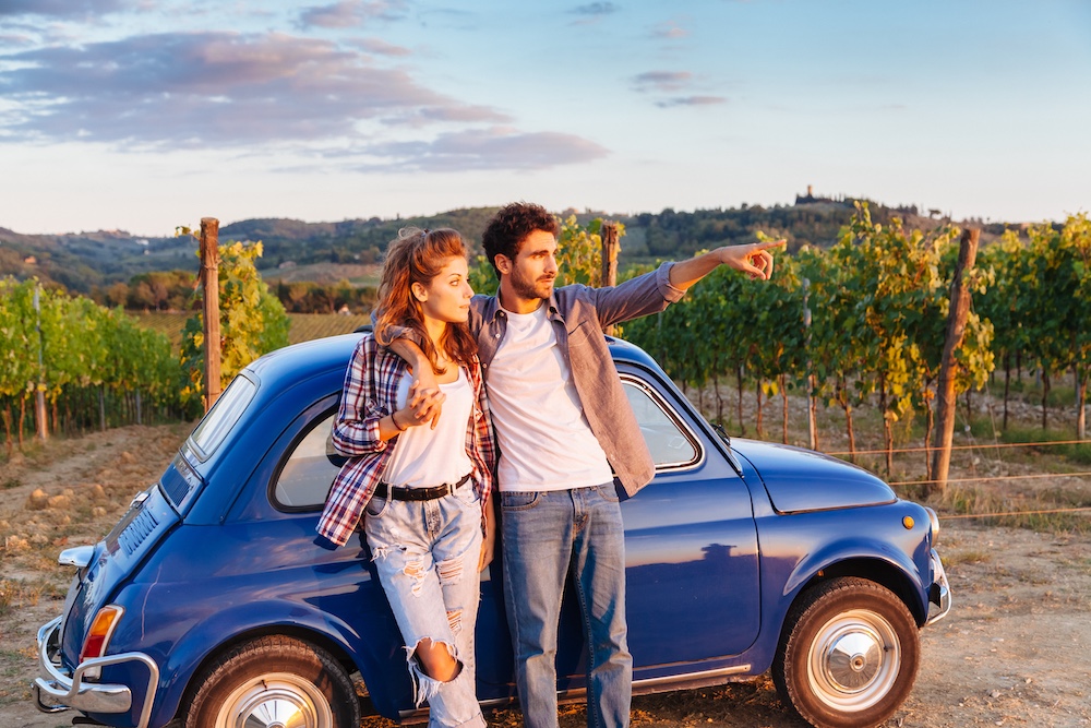 Paar vor einem blauen Oldtimer
